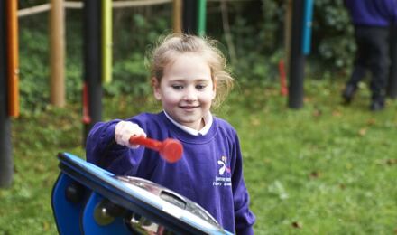 Child playing with musical instrument in forest school