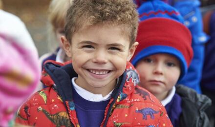 Child smiling to camera in a queue