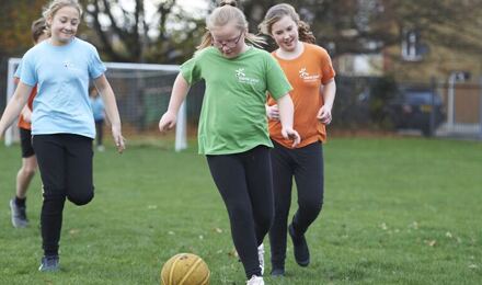 Children playing football on school field