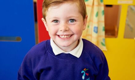 Child smiling to camera with bright background