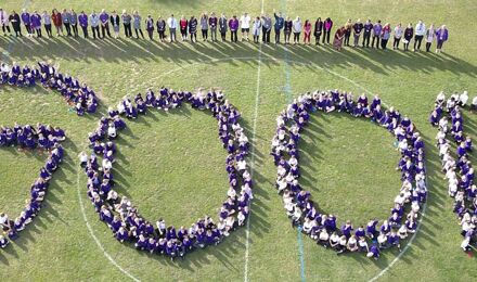 Drone image of children spelling out the word good on school field