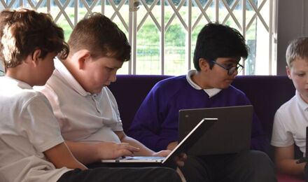 Children concentrating on laptops