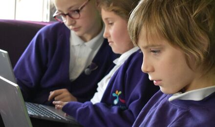 Children concentrating on laptops