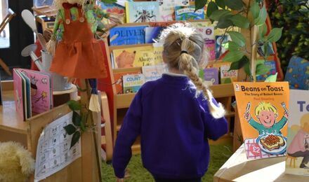 Back of a child walking into book corner