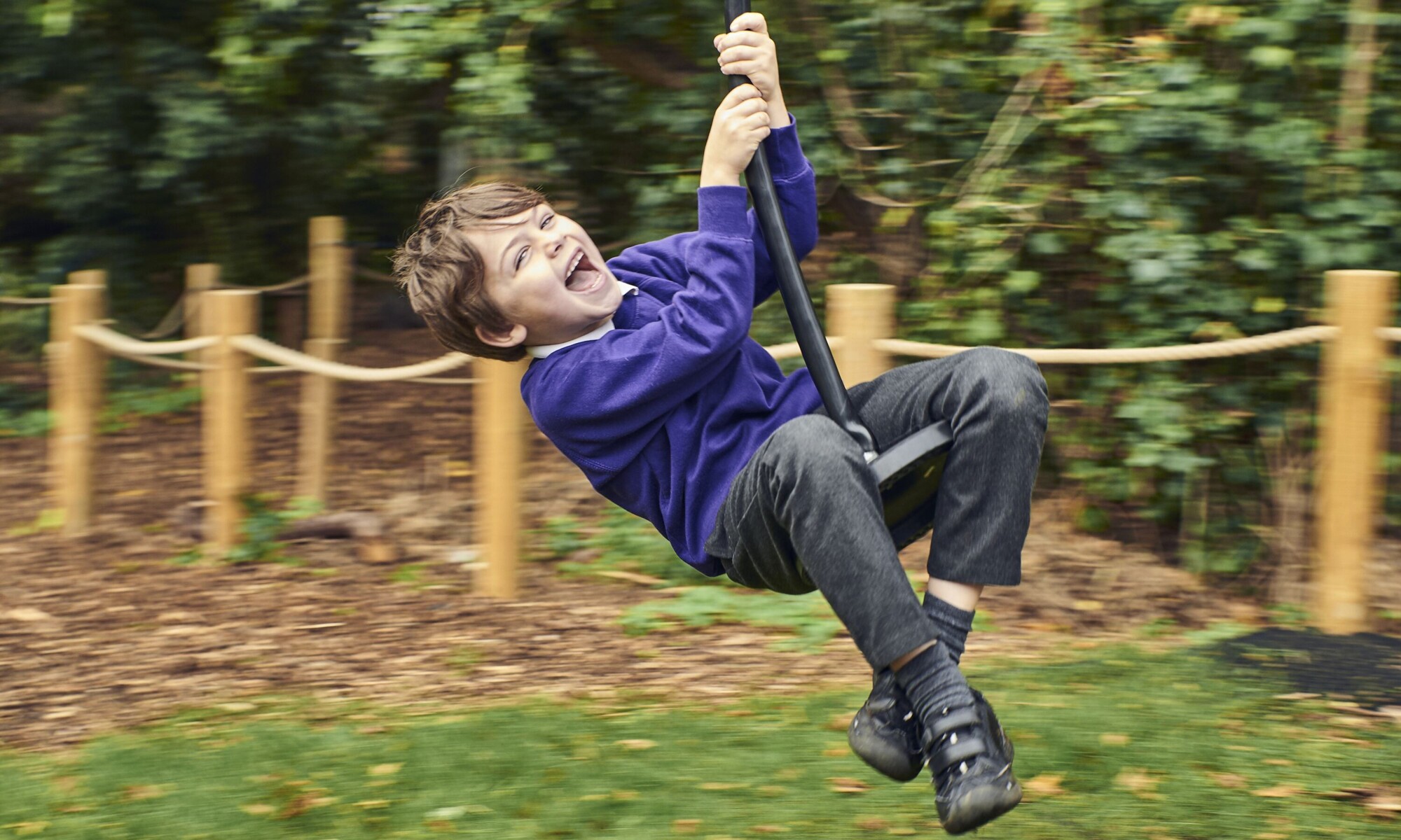 Child playing on the zip wire in forest school